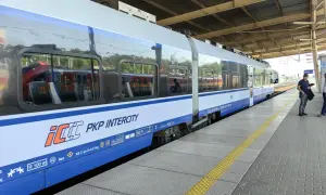 Pociąg PKP Intercity na peronie, z widocznymi oknami i logo przewoźnika.