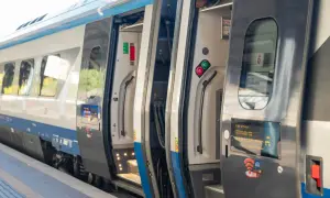 Pociąg PKP z otwartymi drzwiami na peronie. Sprawdź aktualne pkp promocje i podróżuj taniej!