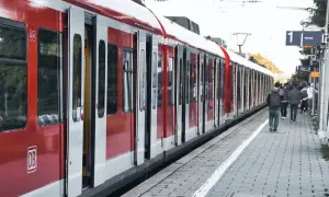 Czerwono-biały pociąg PKP z otwartymi drzwiami na peronie, ludzie czekają.