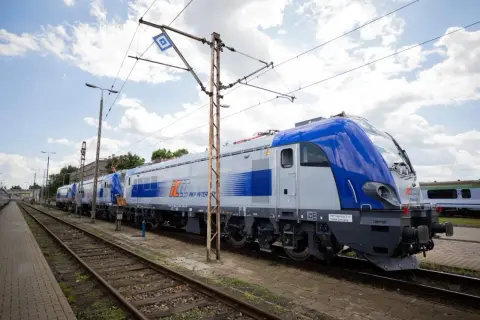 Nowe lokomotywy PKP Intercity, gotowe do podróży z Lublina. Zielona góra w tle, chmury na niebie.