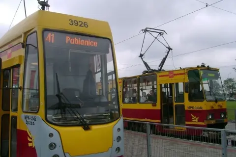 Dwa żółto-czerwone tramwaje MPK Łódź, jeden z napisem "41 Pabianice", stoją na torach.