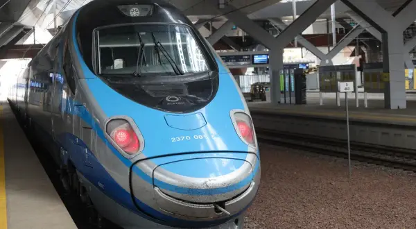 Przód niebiesko-srebrnego pociągu PKP Pendolino na peronie.