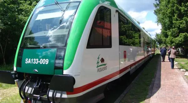Nowy szynobus Białystok Suwałki czeka na pasażerów. Zielono-biały pojazd z logo Podlasia gotowy do podróży.