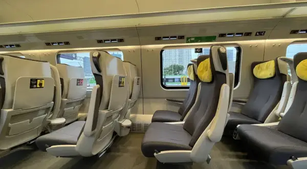 Wnętrze pociągu Pendolino. Fotele klasy 1 i 2, wygodne, z żółtymi zagłówkami, czekają na pasażerów.