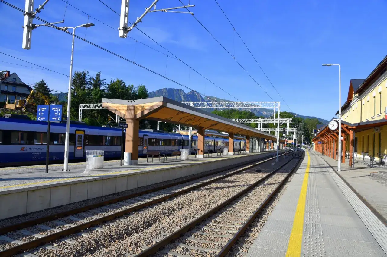 Pociąg PKP Intercity z Kielc do Zakopanego stoi na peronie. Góry w tle zapraszają na podróż.
