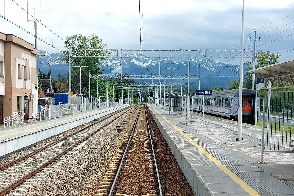 Stacja kolejowa z pociągiem PKP, w tle góry. Idealne miejsce na podróż poznań - zakopane pkp bezpośrednio.