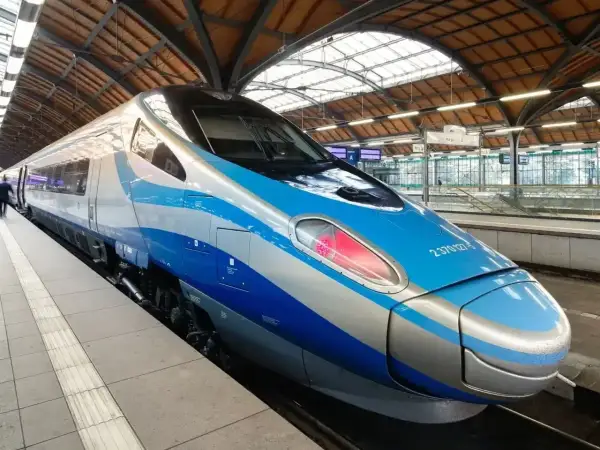 Nowoczesny pociąg Pendolino EIC z niebiesko-srebrnym malowaniem stoi na peronie.