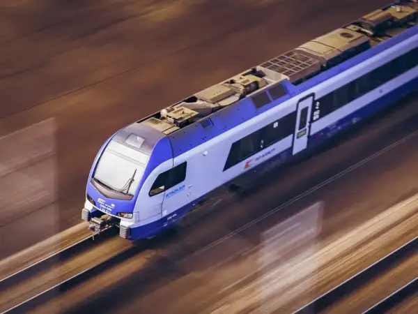 Pociąg Stadler FLIRT pędzi po torach, łącząc Ełk z Białymstokiem.